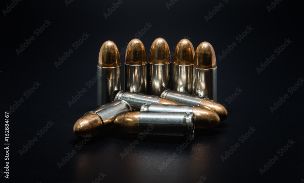 9mm silver bullet for a gun on drak background.Bullet isolated 9mm silver bullet for a gun on drak background.Bullet isolated