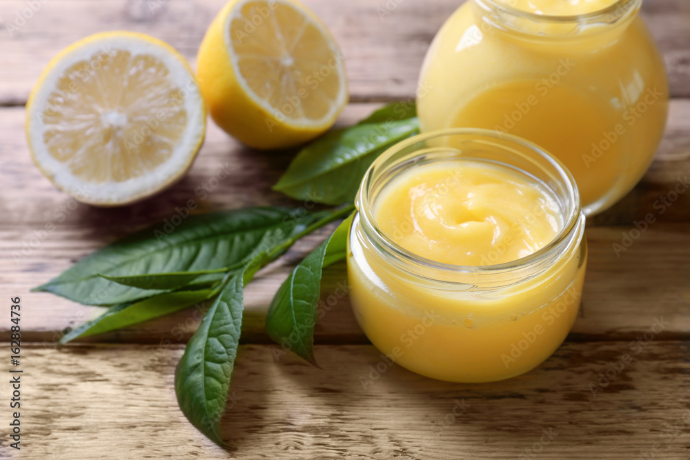 Glass jars with yummy lemon curd on wooden table Glass jars with yummy lemon curd on wooden table