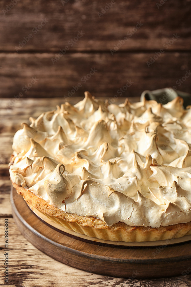 Fototapeta premium Board with tasty lemon meringue pie on wooden table, closeup