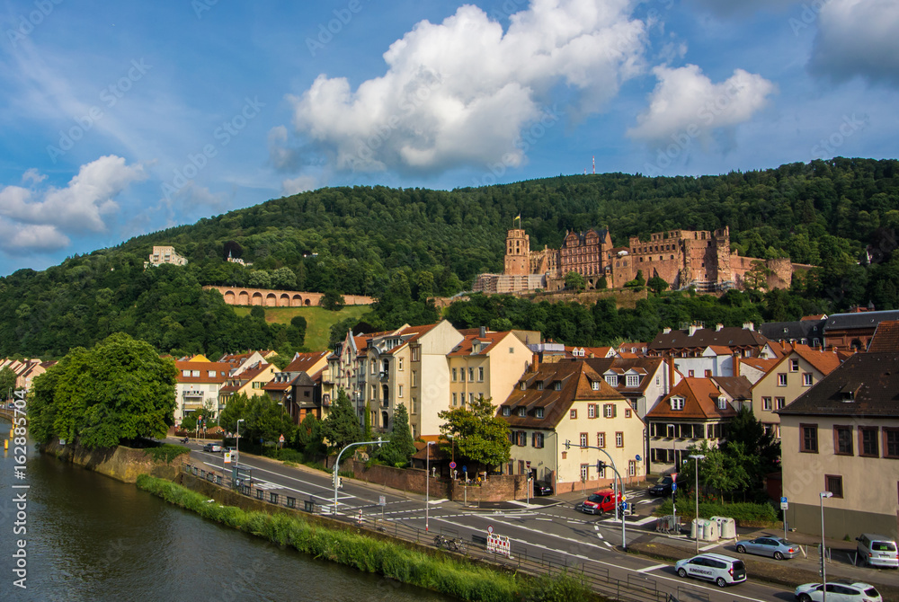 HEIDELBERG, GERMANY - JUNE 4, 2017: Panoramic view of Heidelberg castle over the tile roofs of old town from Carl Theodor bridge, Heidelberg, Germany.