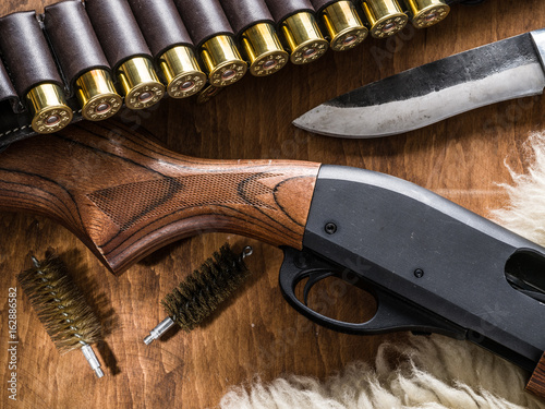 Pump action shotgun, 12 mm hunting cartridge  and hunting knife.