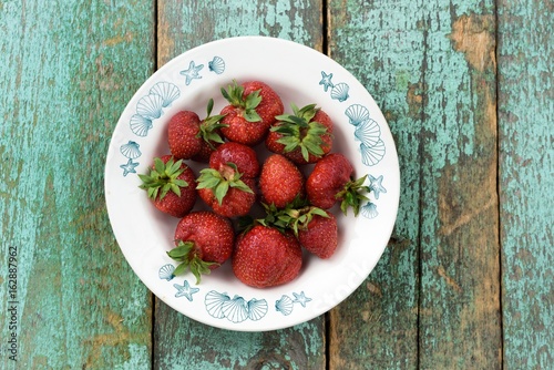 Organic heiroom ripe strawberries on turquoise table photo
