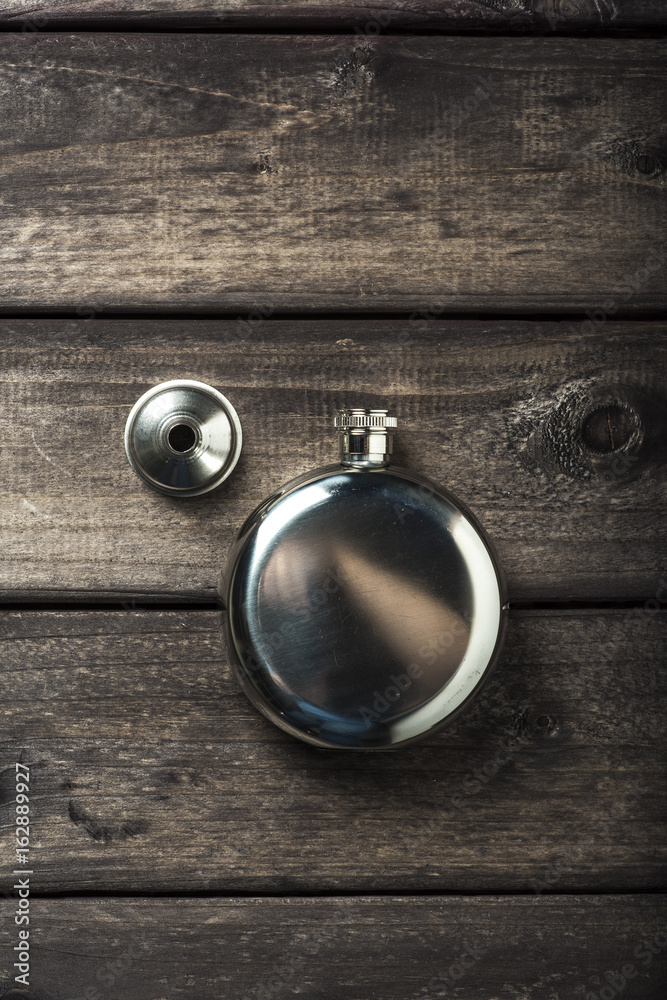 Metall round flask with cup on wooden backdrop Metall round flask with cup on wooden backdrop
