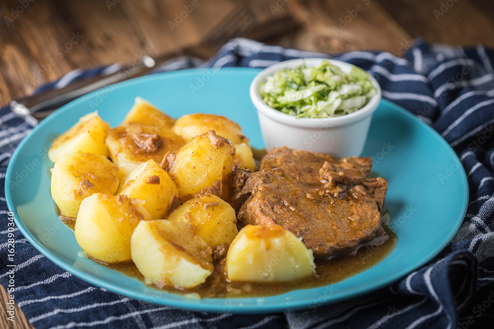 Braised meat in sauce served with boiled potatoes.