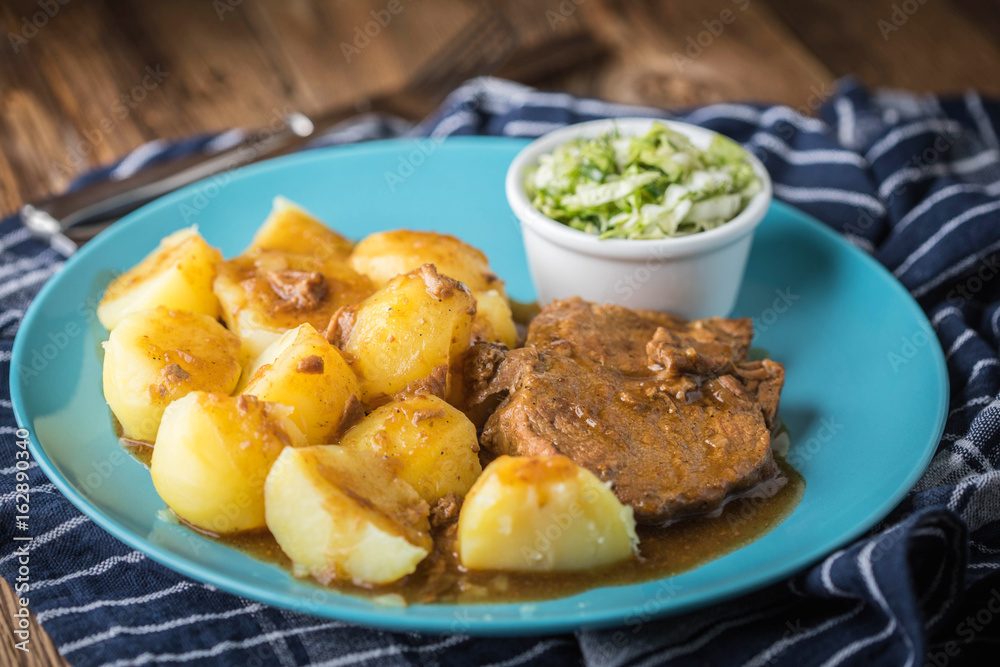 Braised meat in sauce served with boiled potatoes. Braised meat in sauce served with boiled potatoes.