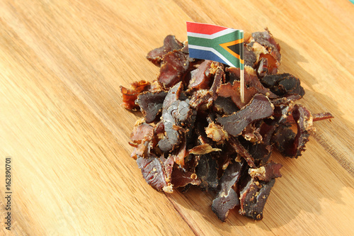Biltong (dried meat) on a wooden board, this is a traditional food snack that can be found in South Africa.