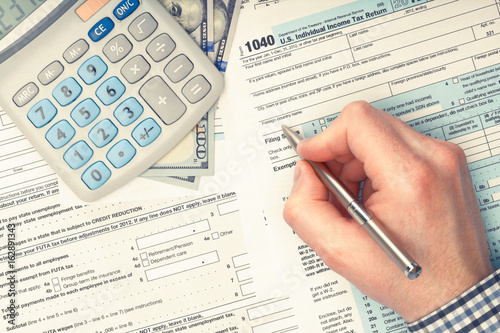 Man filling out 1040 US Tax Form - view from top