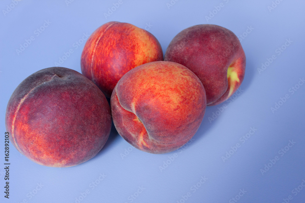 Obraz premium Peaches on a blue background. Empty space for text.