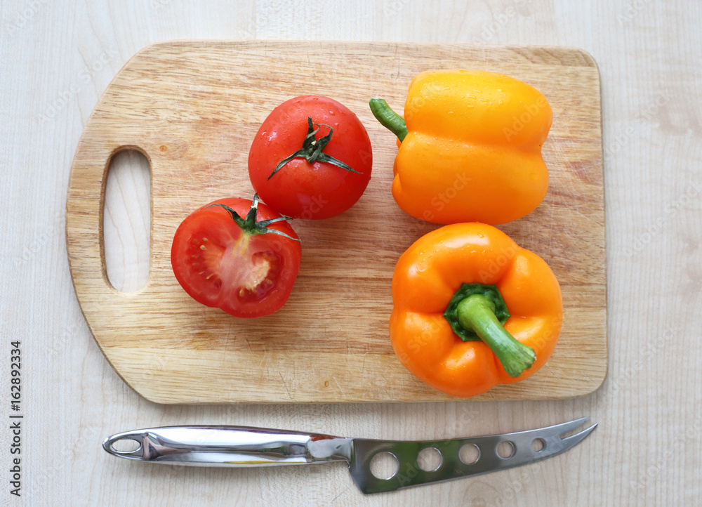 orange bell pepper, tomato on Board orange bell pepper, tomato on Board