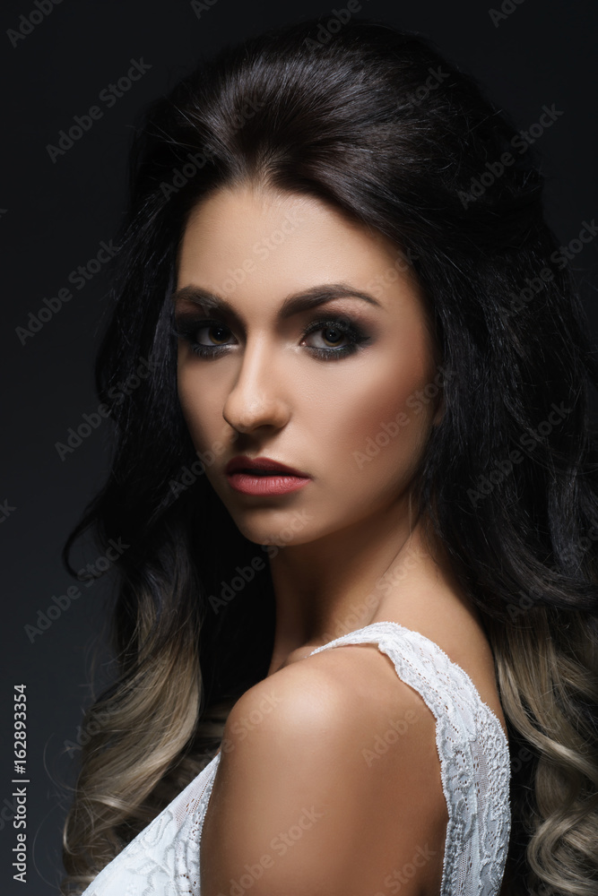 Fototapeta premium Beautiful portrait of young and attractive woman. Human face over dark background.