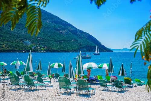 Fototapeta Naklejka Na Ścianę i Meble -  Chairs and umbrellas on the famous beach of Lefkada Poros, in summer holiday, Greece