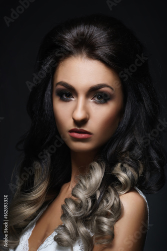 Beautiful portrait of young and attractive woman. Human face over dark background.