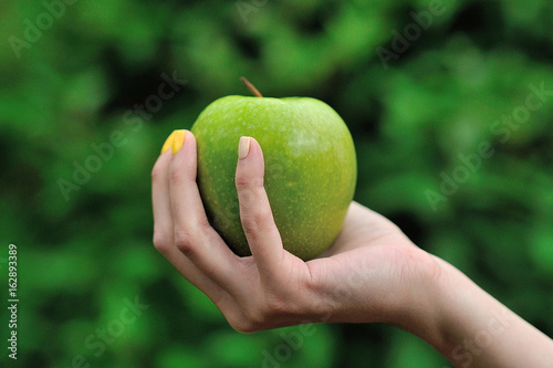 A female hand with green apple