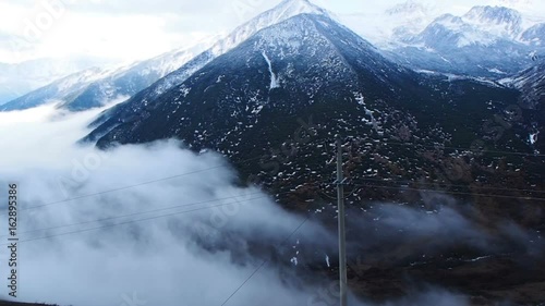 View of fog covered the valley of high snow mountain in Sichuan, China photo