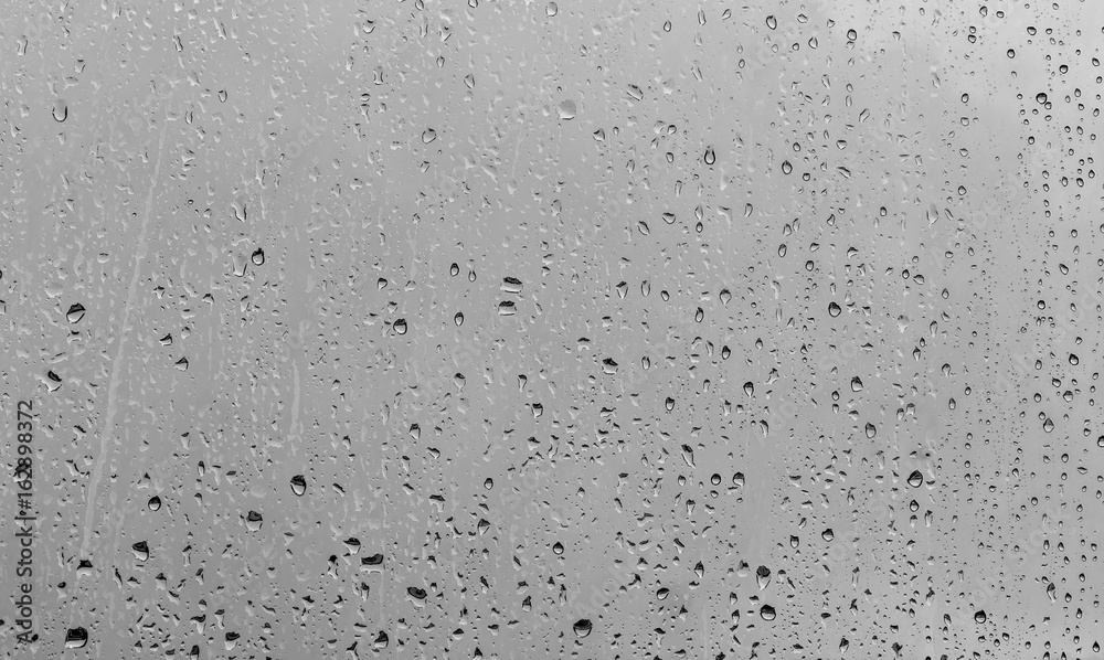 Rain drops on window glasses background. Natural Pattern of raindrops isolated on gray background. Rain drops on window glasses background. Natural Pattern of raindrops isolated on gray background.