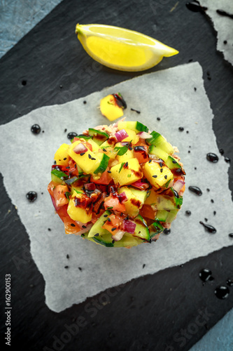 Tuna sushi stacks with mango, cucumber, tomatoes salsa served with balsamic vinegar, nigela ans sesame seeds photo