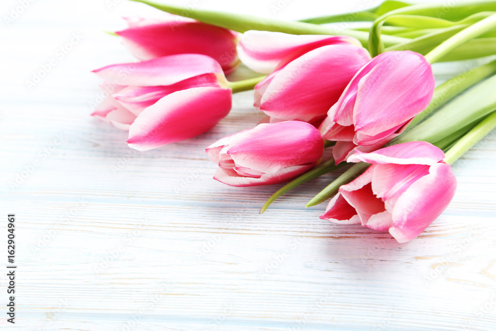 Bouquet of pink tulips on white wooden table