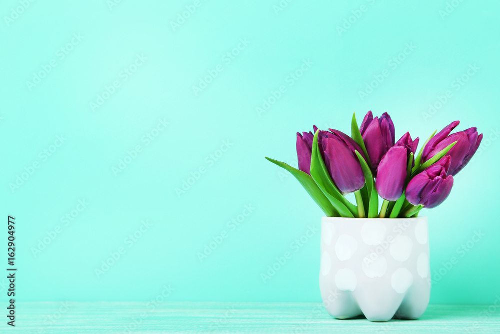 Bouquet of tulips in cup on green background Bouquet of tulips in cup on green background