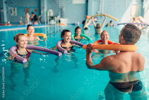 Fototapeta Naklejka Na Ścianę i Meble -  Aqua aerobics exercises, women with male trainer