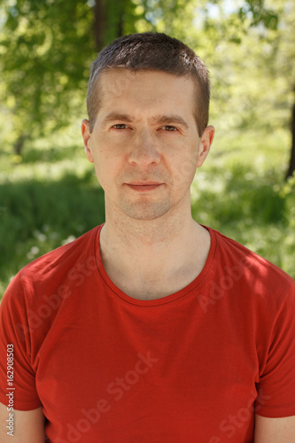 The man in a red t-shirt and jeans in the park © Arsentyev Vladimir