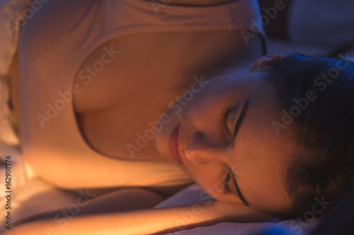 The cute woman lay on the bed. night time