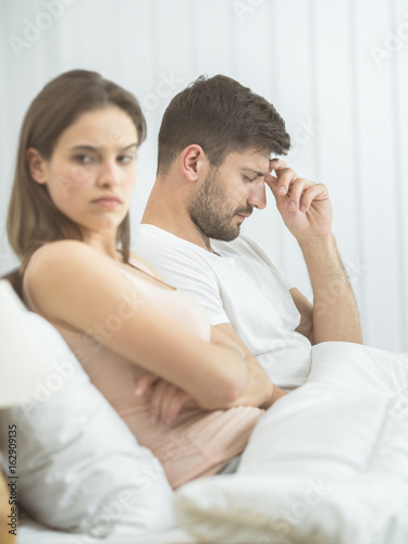 The man with a headache sit near woman on the bed © realstock1