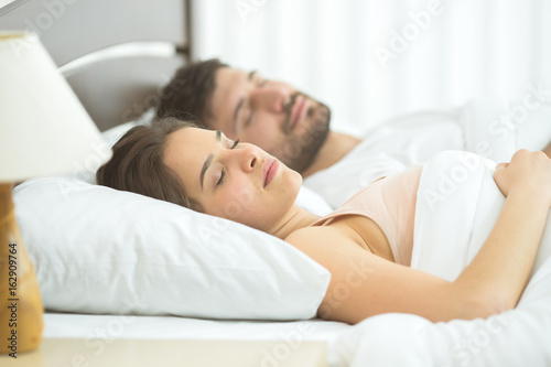 The man and woman sleeping in the comfortable bed