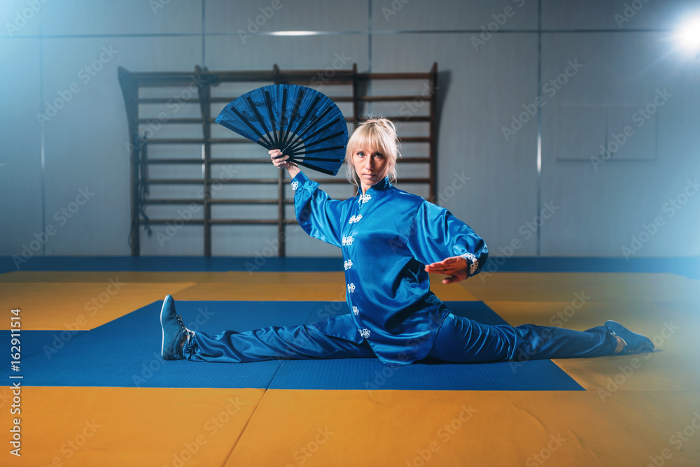 Female wushu master exercise with fan, martial art