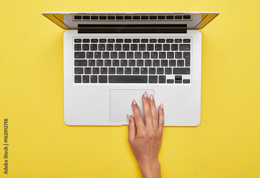 Female hand using touchpad of laptop - obrazy, fototapety, plakaty 