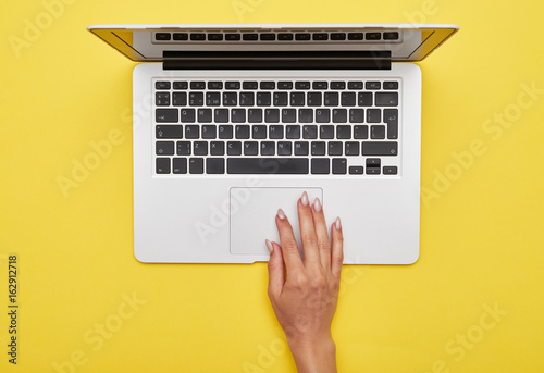 Foto Female hand using touchpad of laptop