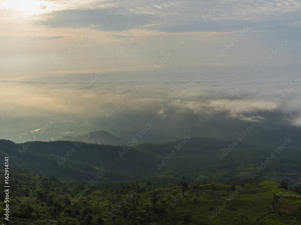 Obraz premium Mgła i chmury górski krajobraz z promieniami słońca w rano