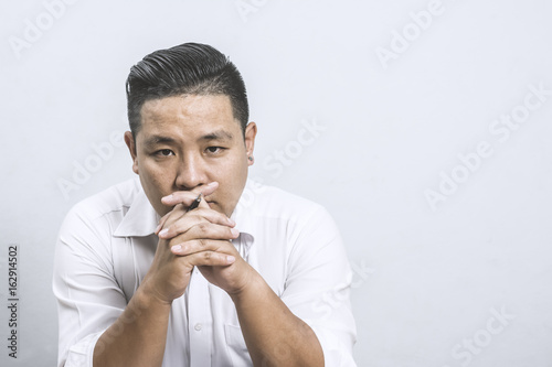 Portrait of thinking Asian businessman.