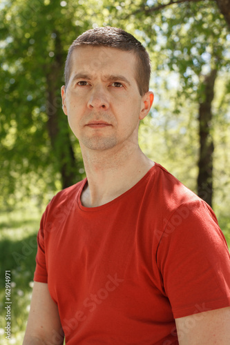 The man in a red t-shirt and jeans in the park