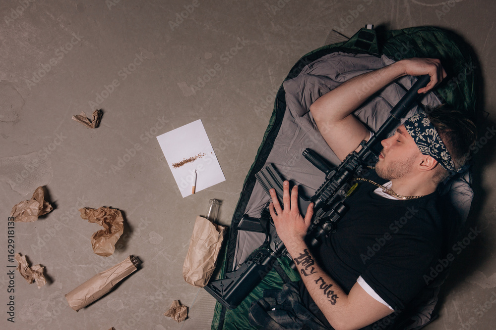 Soldier is sleeping with a rifle. Bad habits. Cigarette, alcohol ...