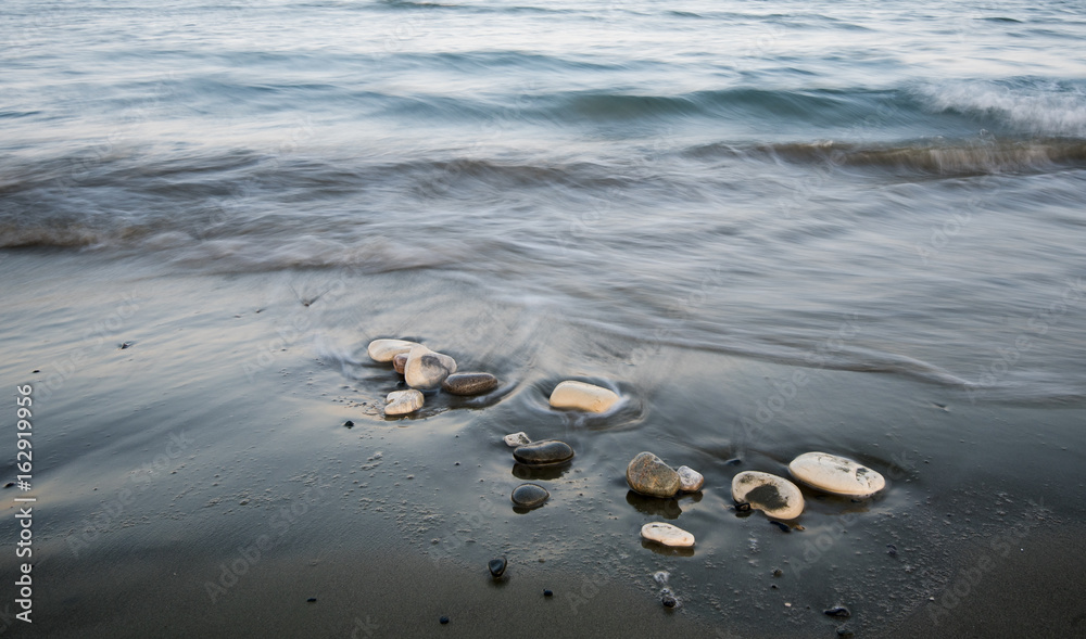 Pebbles in the beach and flowing sea water Pebbles in the beach and flowing sea water