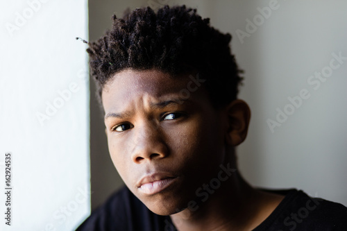 Concerned worried young African boy photo