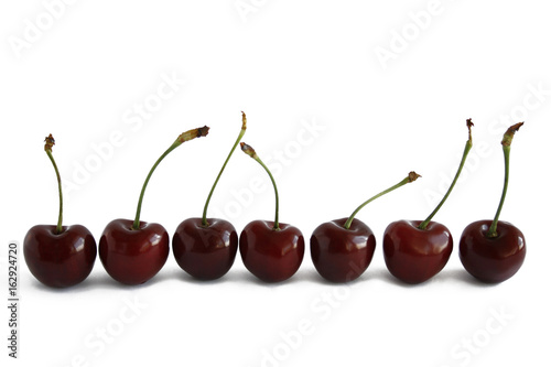 Row of cherries on white background