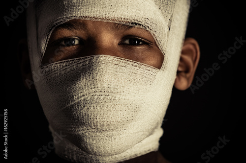 Obraz na plátně Young black boy with bandages on his face