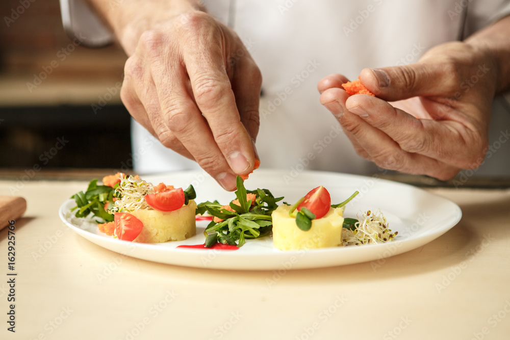 Mature man professional chef cooking meal indoors Mature man professional chef cooking meal indoors