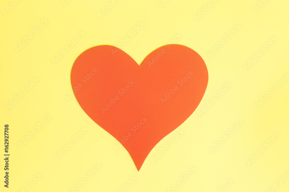 Red paper Valentines Day heart on yellow background