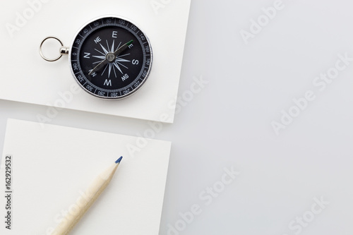 Business direction concept ,business white paper with compass and pencil on white background. photo