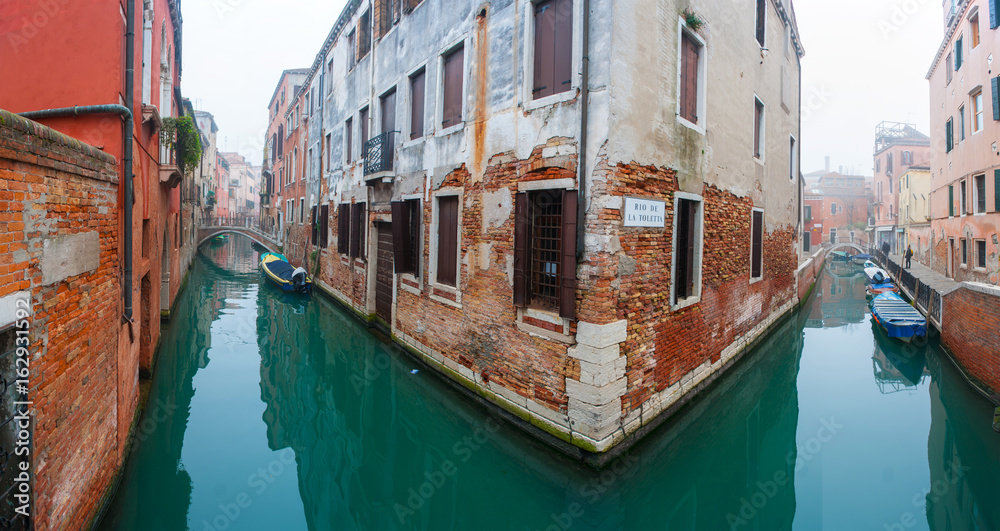 Vintage red brick house and gondola in grand canal, Venice.