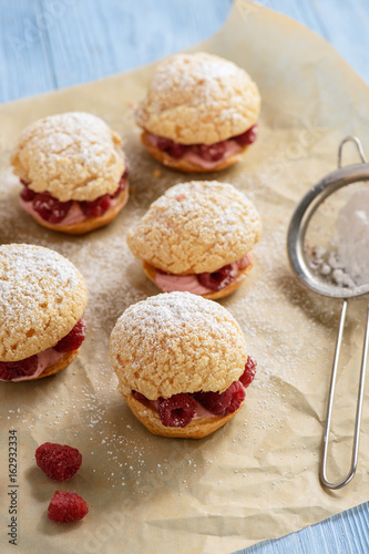 Eclairs with mascarpone cream and raspberries. photo