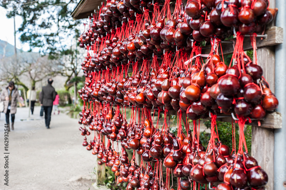 Naklejka premium Red dry bottle gourd hanging on bar, item for luck in the temple.