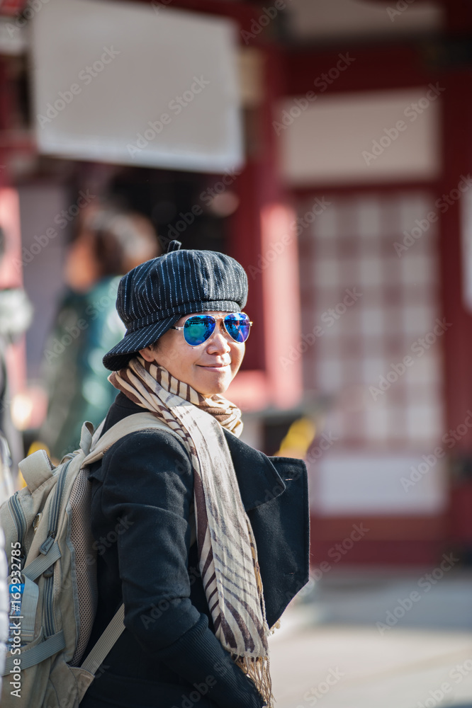 Asian senior female tourist in winter costume traveling at Dazaifu temple, in Japan.
