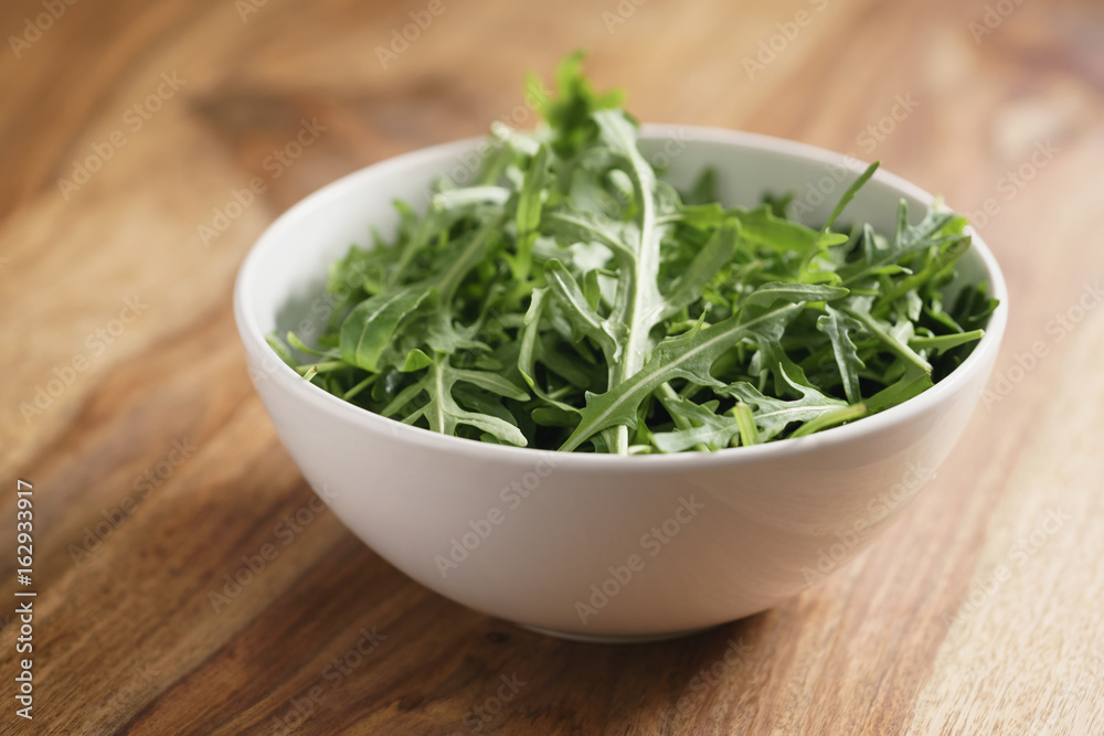 fresh green rocket salad arugula leaves in white bowl fresh green rocket salad arugula leaves in white bowl