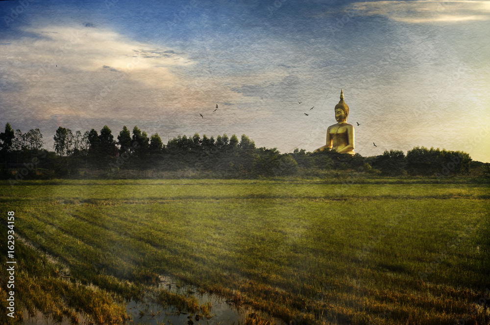 Digital effect on paper texture, image of Buddha statue scene in panoramic rice field twilight of Wat Muang temple, Thailand