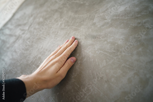 young man hand touching concrete wall photo