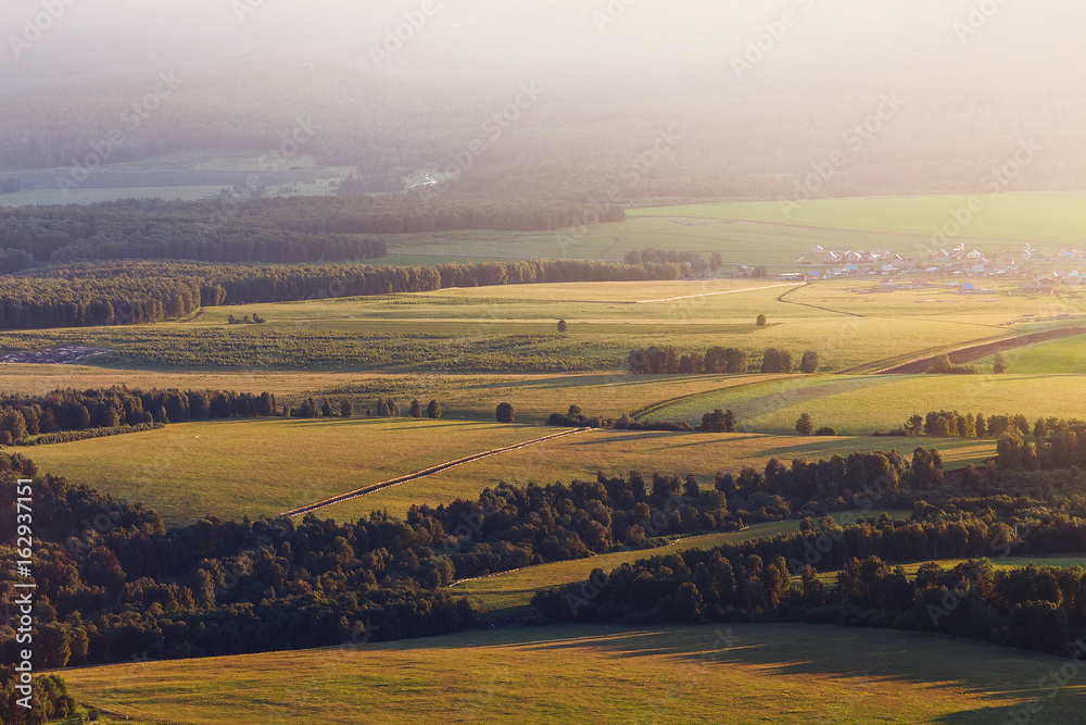 Aerial view of rural landscape at sunset with green meadow, agricultural concept