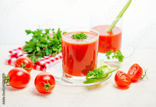 tomato juice in transparent glasses with parsley  cucumber and red napkin  concept healthy eating  close up